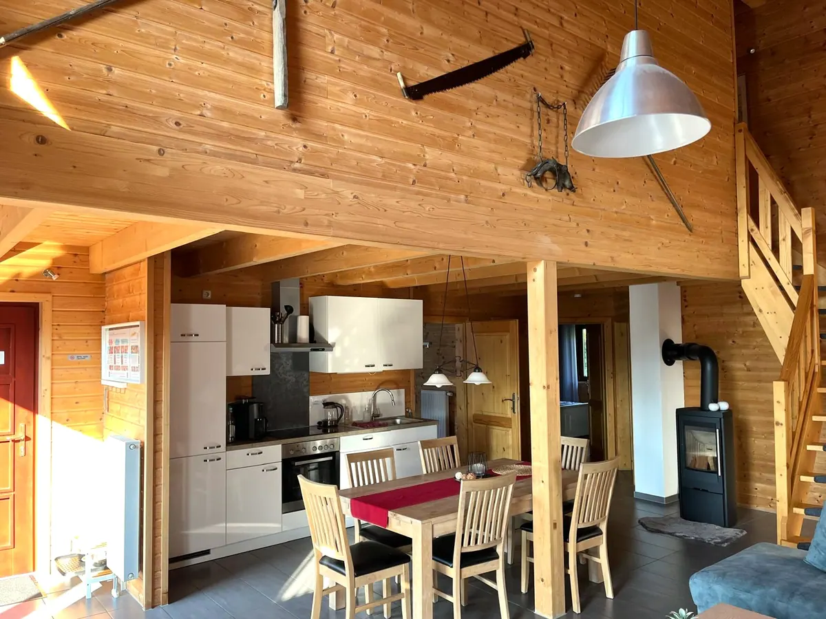 Essbereich mit Holztisch und Kaminofen im Ferienhaus Annika