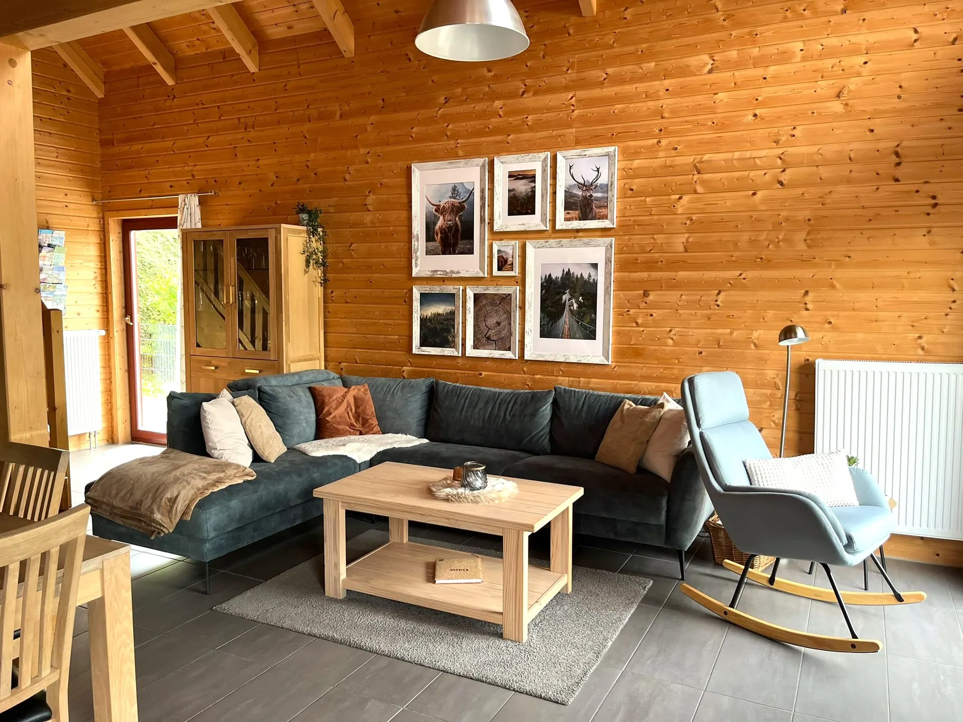Wohnzimmer im Ferienhaus Annika mit grünem Ecksofa und Couchtisch