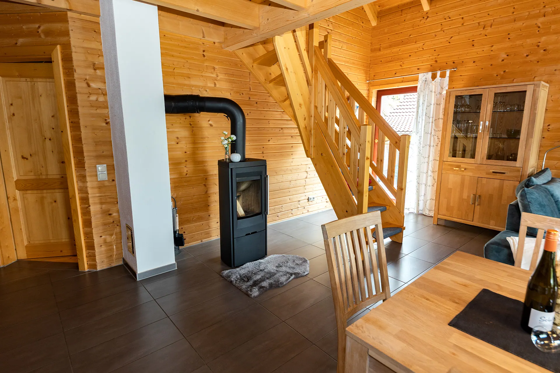 Kaminofen neben der Holztreppe ins Obergeschoss