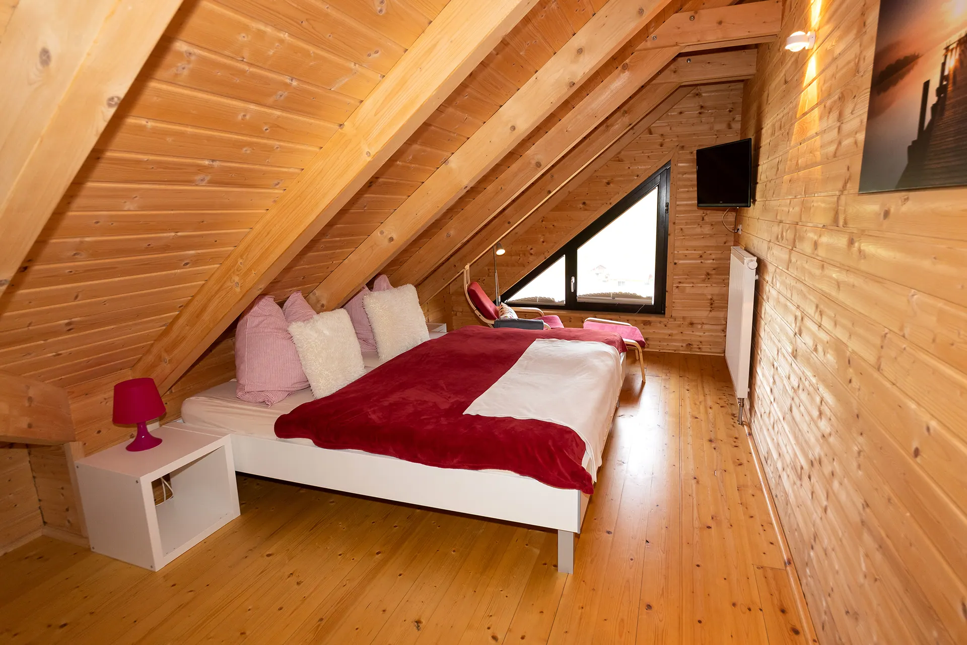 Schlafzimmer unter dem Dach mit Doppelbett und Dachfenster