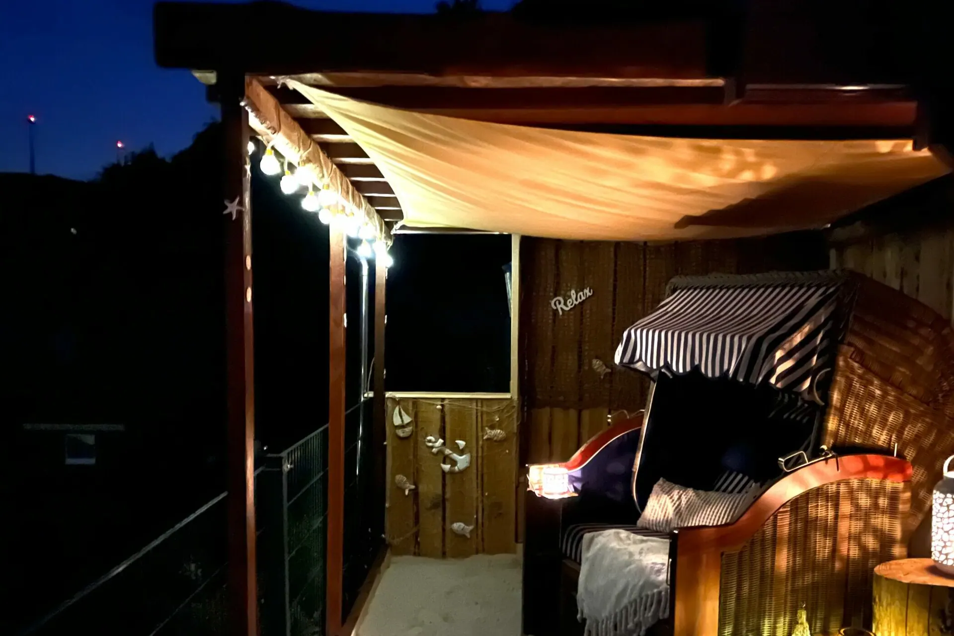 Beach House am Abend: beleuchtete Strandkörbe unter dem Sonnensegel
