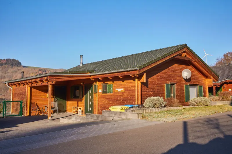 Ferienhaus Susi am Waldsee Rieden: Holzchalet mit überdachter Terrasse und grünen Fensterläden