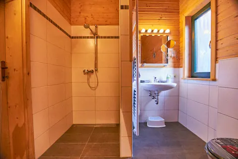 Badezimmer im Ferienhaus Susi mit bodengleicher Dusche und Waschbecken