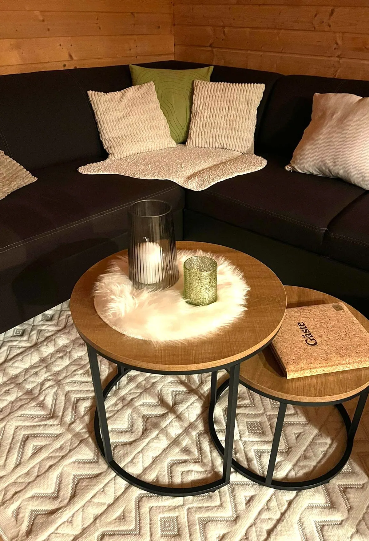 Beistelltisch mit Windlicht und Fellkissen vor der Sofaecke
