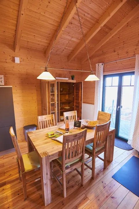 Essbereich im Ferienhaus Susi mit massivem Holztisch und Blick auf die Terrasse