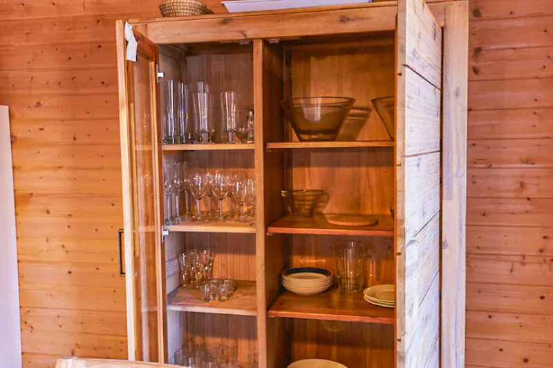 Geöffneter Geschirrschrank mit Gläsern und Schalen