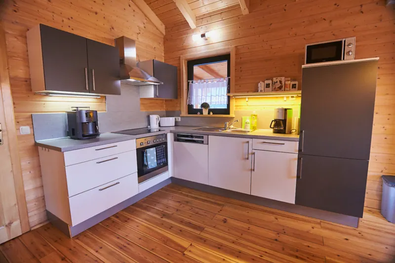 Helle Küche mit weißen Fronten und Holzdecke im Ferienhaus Susi