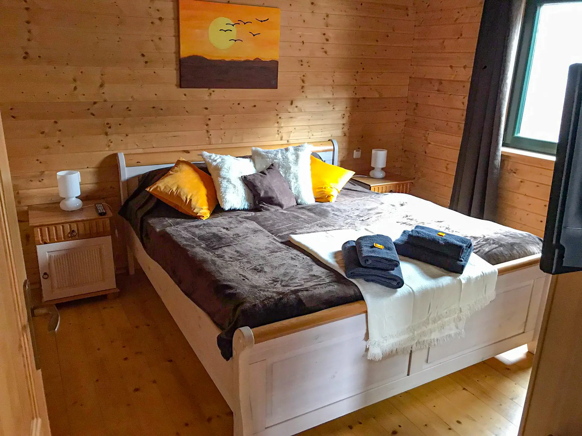 Schlafzimmer im Ferienhaus Susi mit Doppelbett und Holzwänden