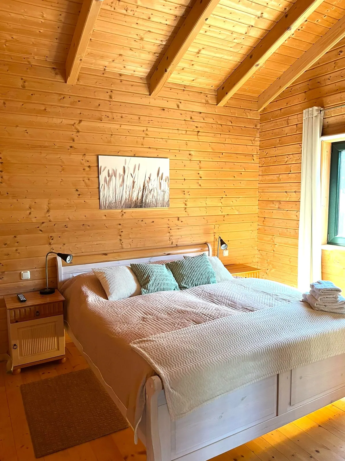 Zweites Schlafzimmer mit bezogenem Doppelbett und Sessel