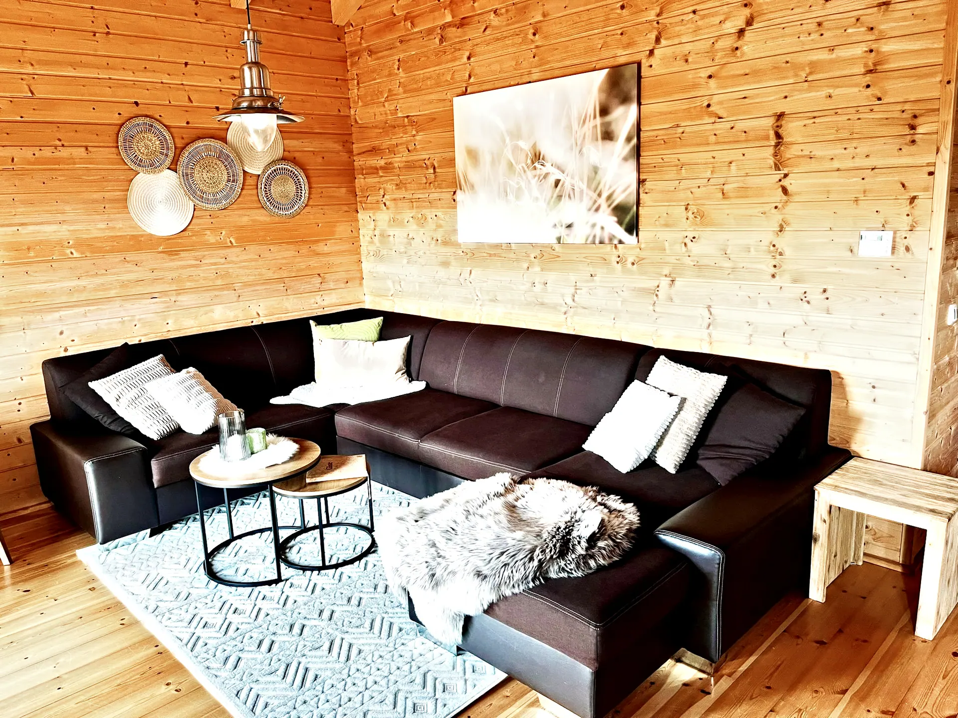 Gemütliche Sofaecke im Wohnbereich mit Fellkissen und Couchtisch