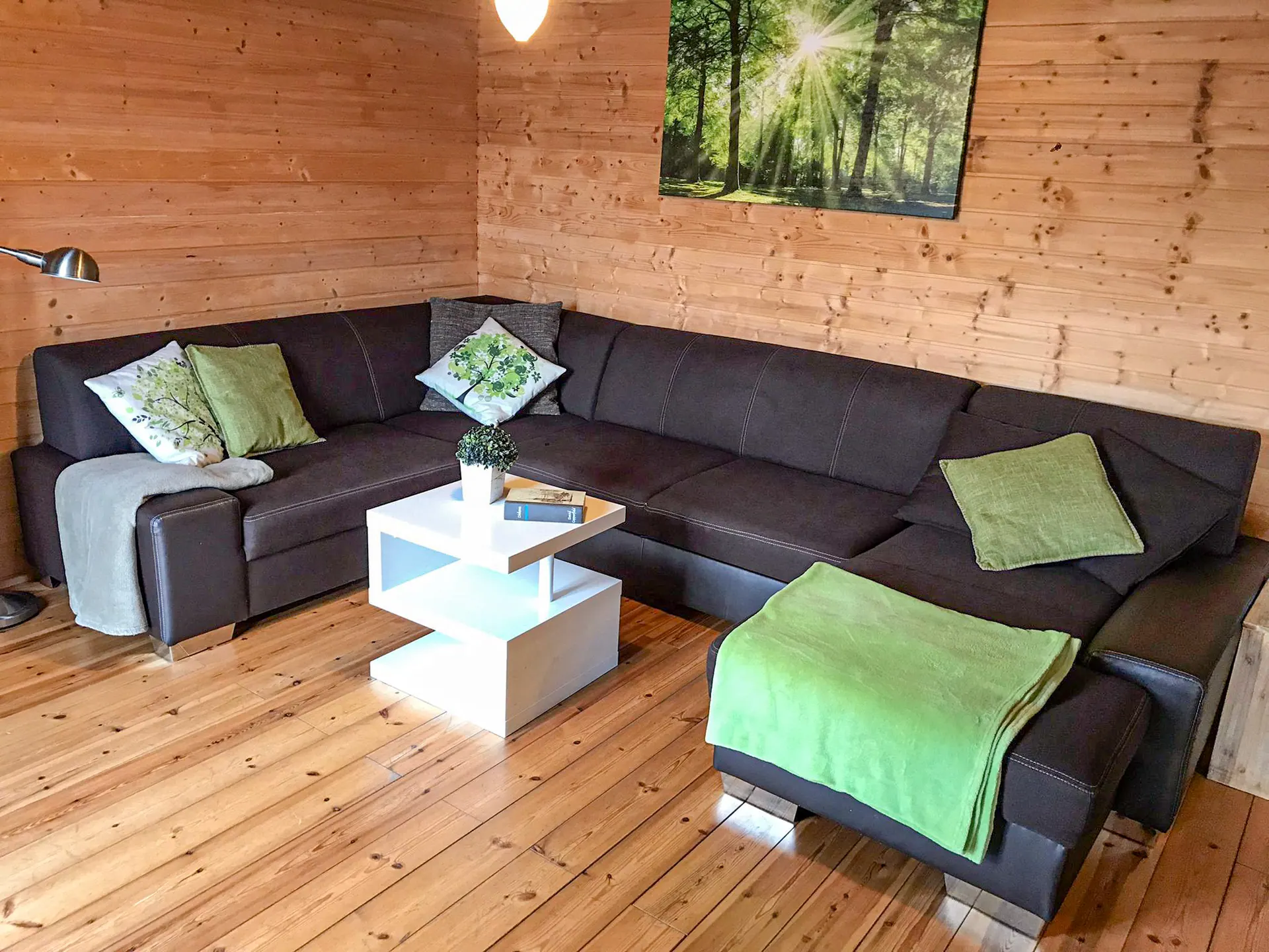 Wohnbereich mit L-förmigem Sofa und Wandbild im Ferienhaus Susi