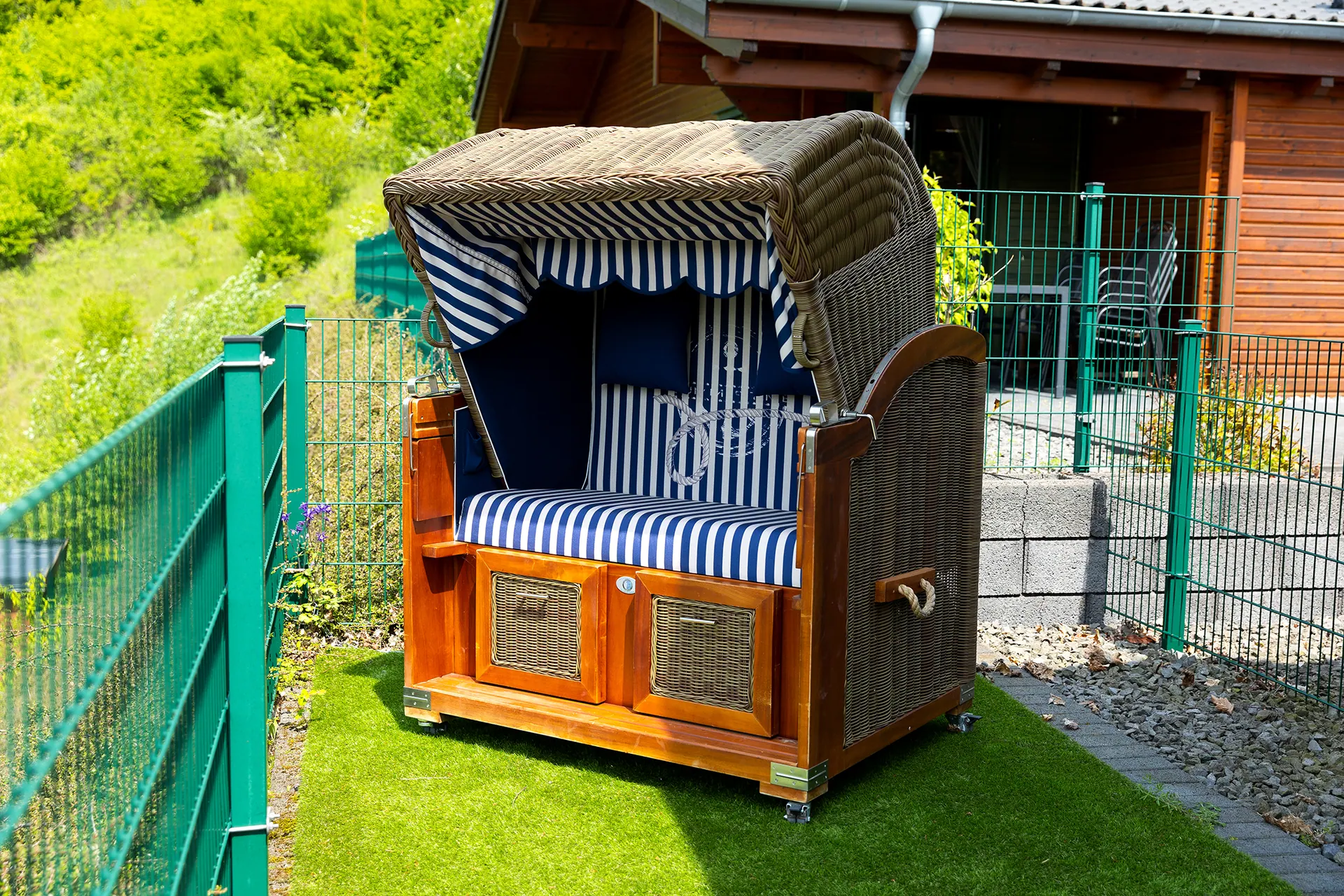 Blau gestreifter Strandkorb im eingezäunten Garten vom Ferienhaus Susi