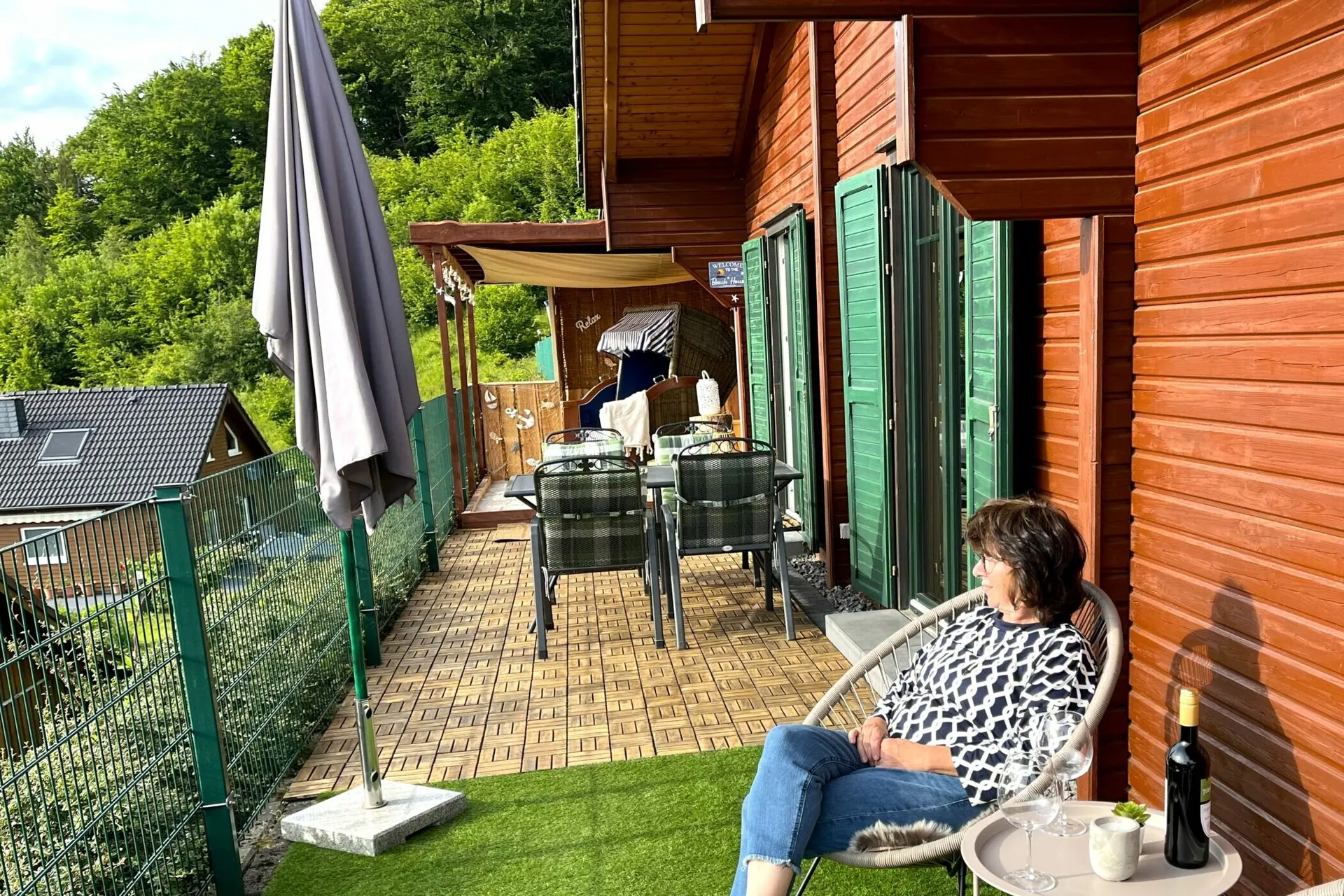 Sonnige Terrasse mit Sonnenschirm und Sitzgruppe vor dem Ferienhaus