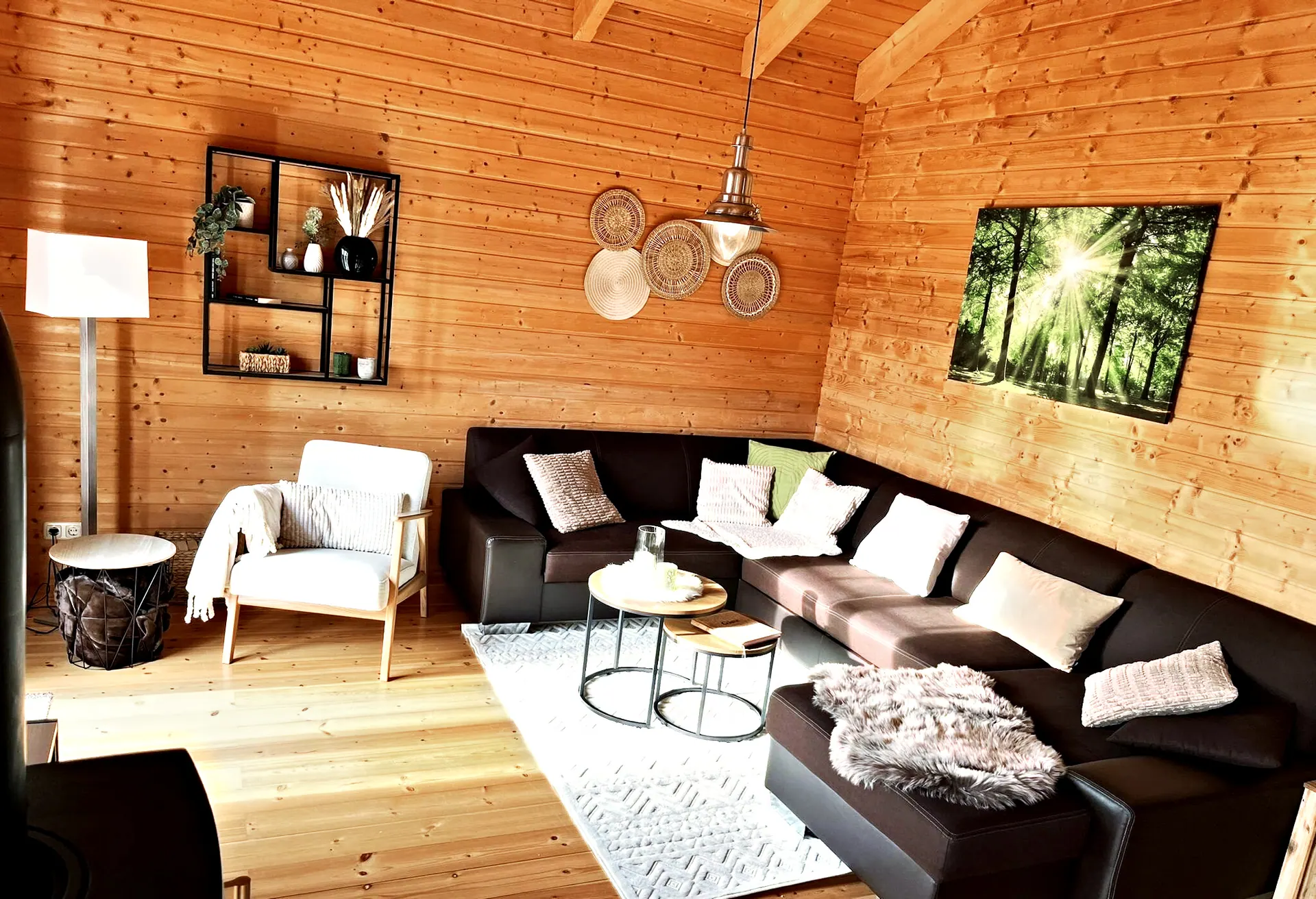Wohnzimmer im Ferienhaus Susi mit großer Ledercouch, Sessel und heller Holzdecke