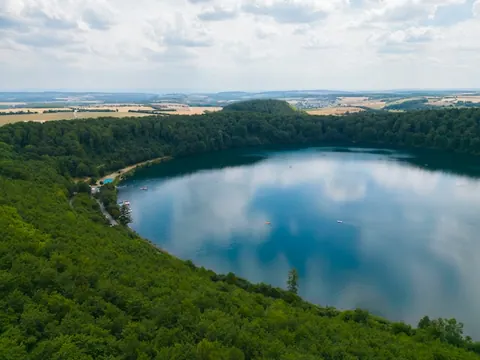 Blick über den Laacher See auf die Türme der Abteikirche Maria Laach
